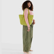 Baggu Lemongrass Cloud Bag worn over a woman's shoulder