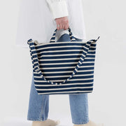Person holding a Baggu horizontal zip duck bag in Navy Stripe in their hands