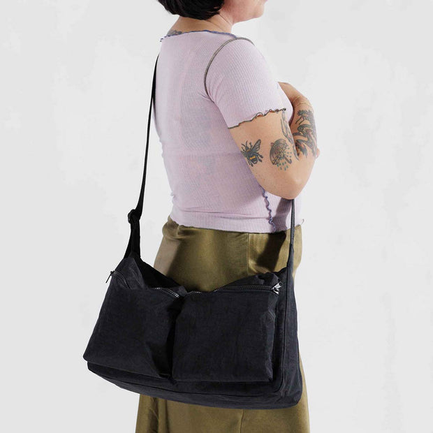 A person holding A Baggu Large Cargo Crossbody bag in Black