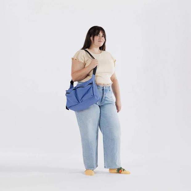 A Baggu Large Cargo Crossbody bag in Pansy Blue worn over the shoulder
