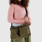 Close up of person holding a Baggu Large Cargo Crossbody bag in Seaweed