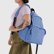 A person holding A large recycled nylon backpack from BAGGU in the Pansy Blue colour way