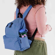 A person wearing A medium recycled nylon backpack from BAGGU in the Pansy Blue on their back