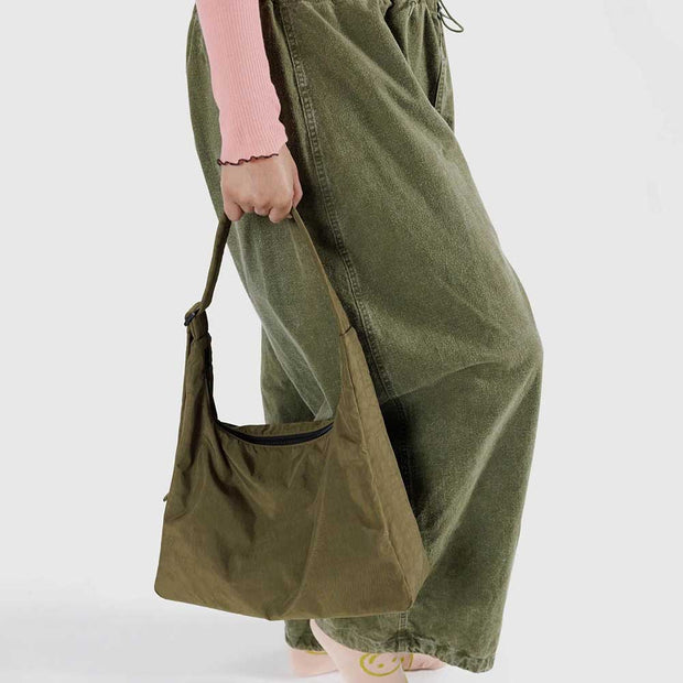 A close up of a woman holding A Seaweed recycled nylon Shoulder Bag from Baggu