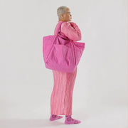 Woman holding Baggu Travel Cloud Bag in Extra Pink
