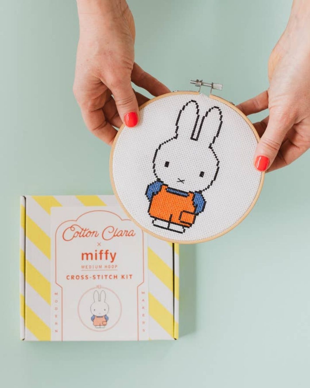 A cross-stitched dungaree Miffy bunny in an embroidery hoop, embroidery kit.