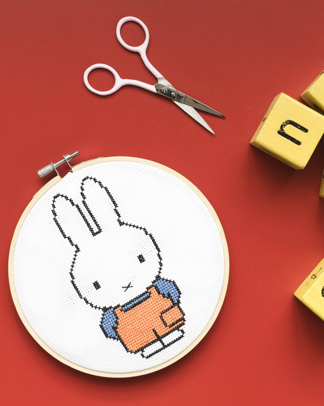 A cross-stitched Miffy bunny in an embroidery hoop, embroidery kit.