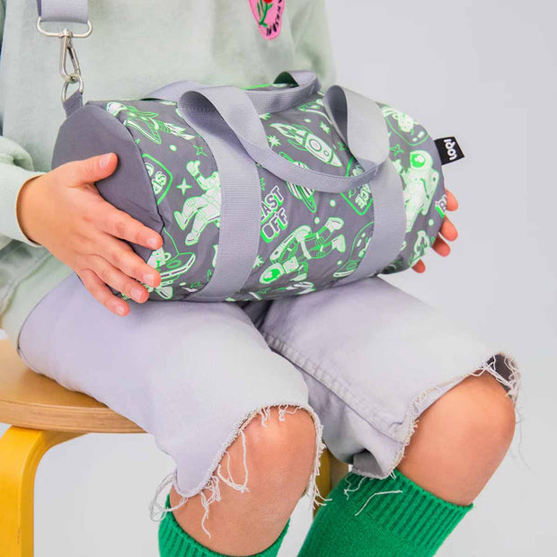 A LOQI REFLECTIVE Space Out Mini Weekender Bag held by a child on their lap