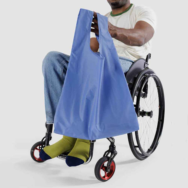 Person in wheelchair holding A Pansy Blue Standard Baggu