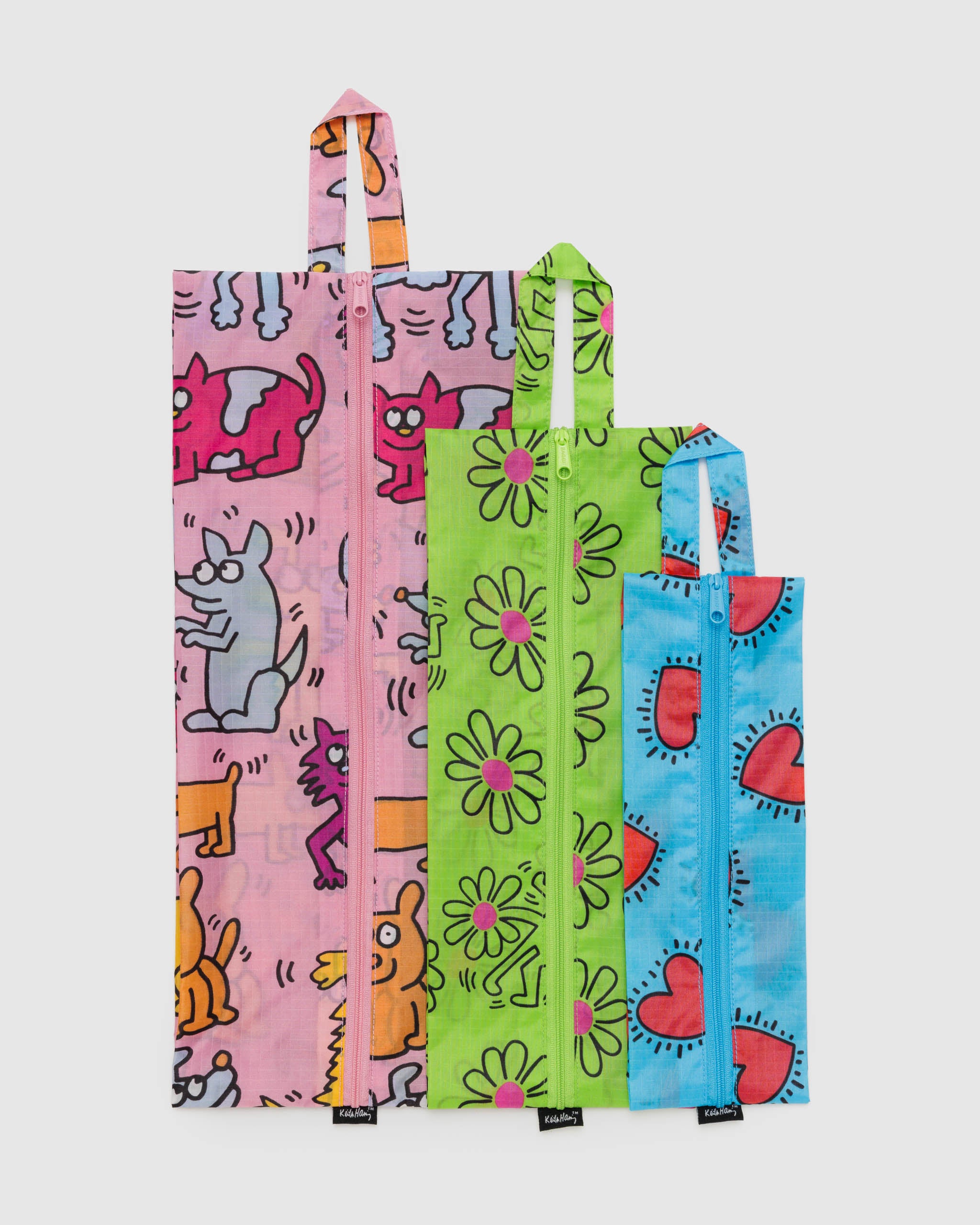 A Set of three BAGGU x Keith Haring 3D Zip pouches laid flat