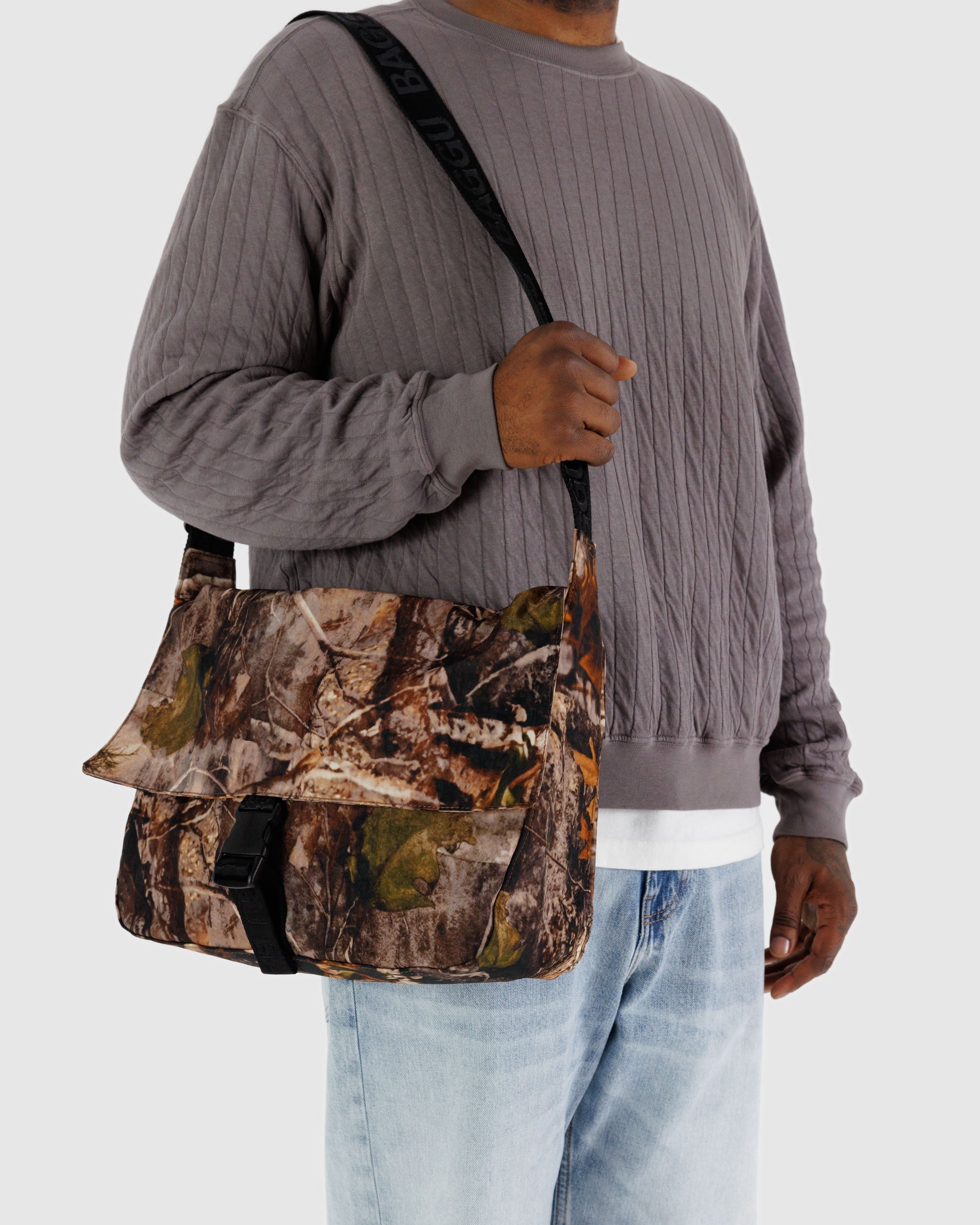 Close up of a person holding a BAGGU  nylon messenger bag in Photo Forest