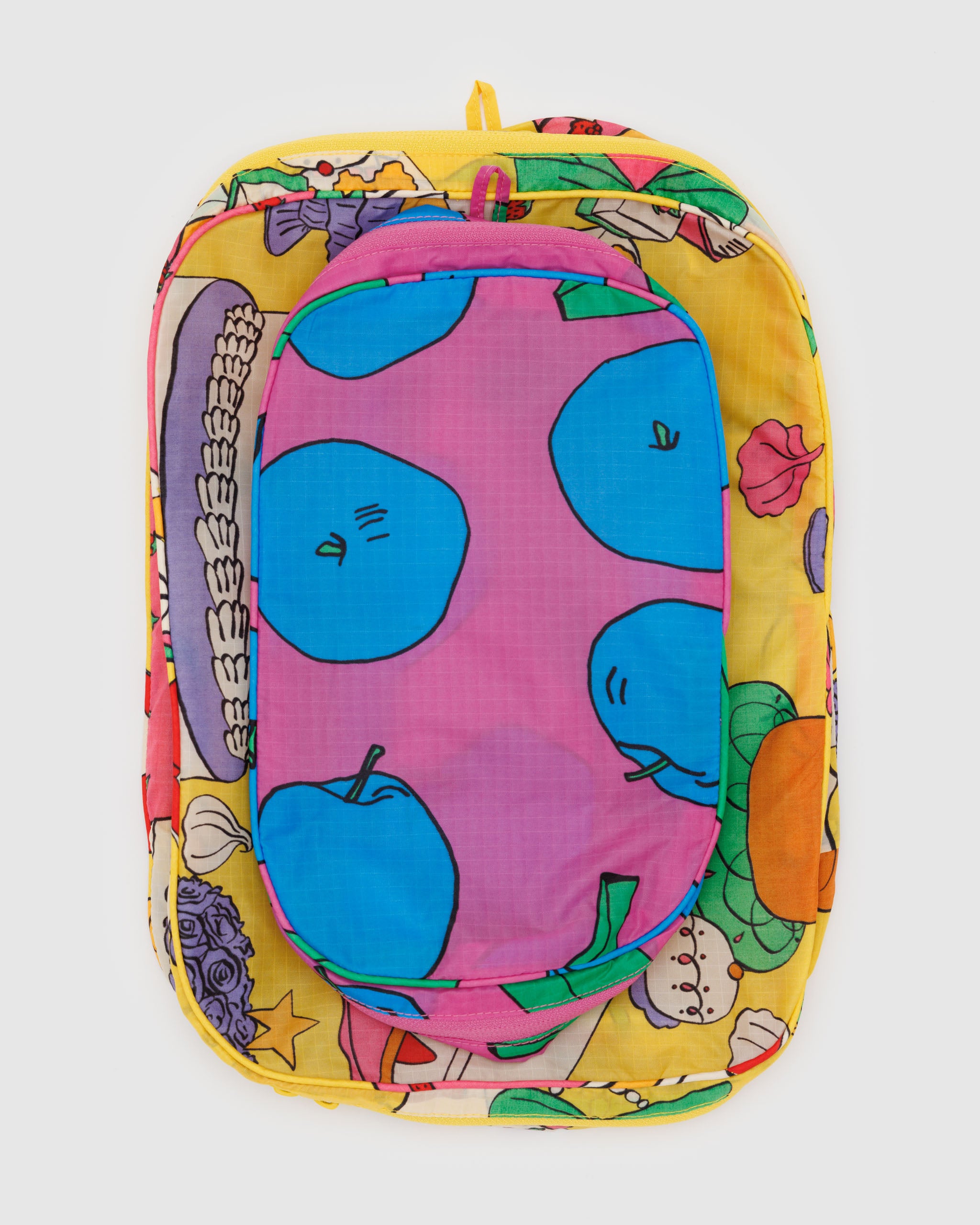 A set of BAGGU packing cubes in Still Life shown in a suitcase