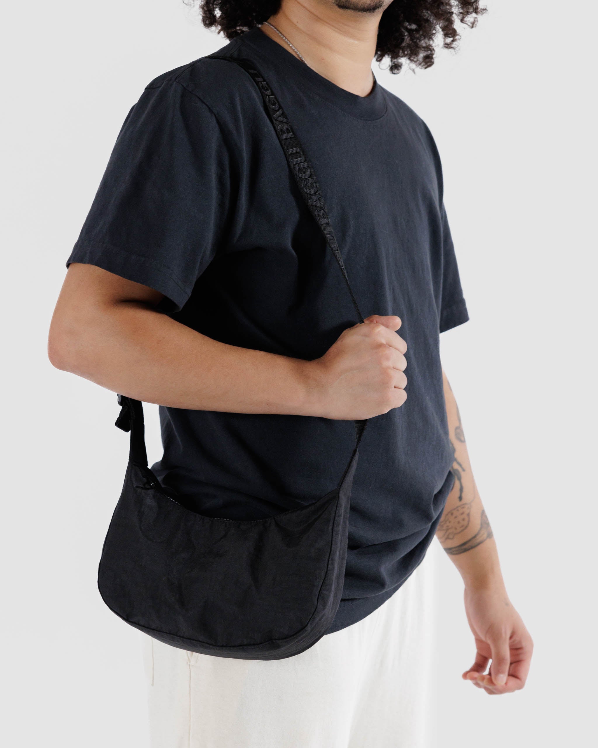One small Crescent Bag from Baggu in Black worn over the shoulder