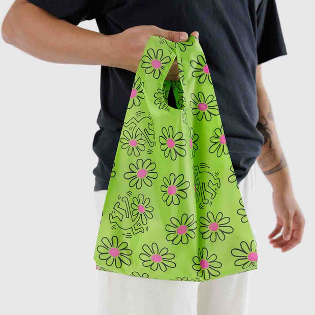 A person holding a Keith Haring Flowers design reusable and recycled Baby Baggu