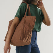 Woman holding a Baggu Brown Cloud Bag