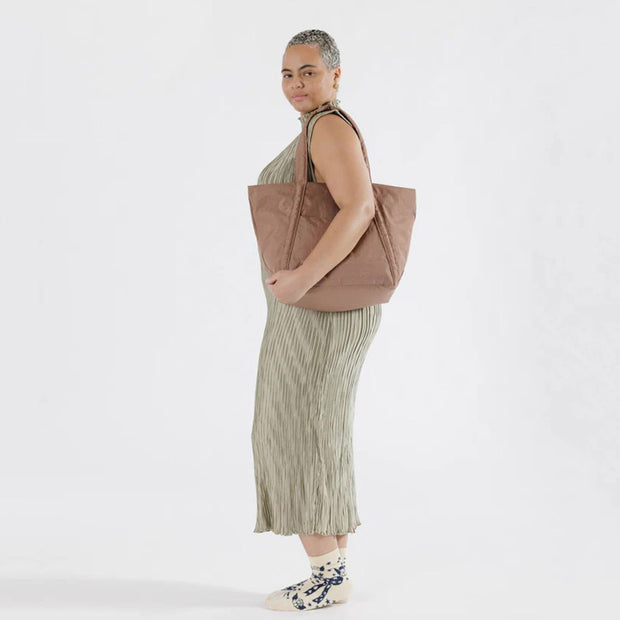 Woman holding a Baggu Cocoa Cloud Bag over her shoulder