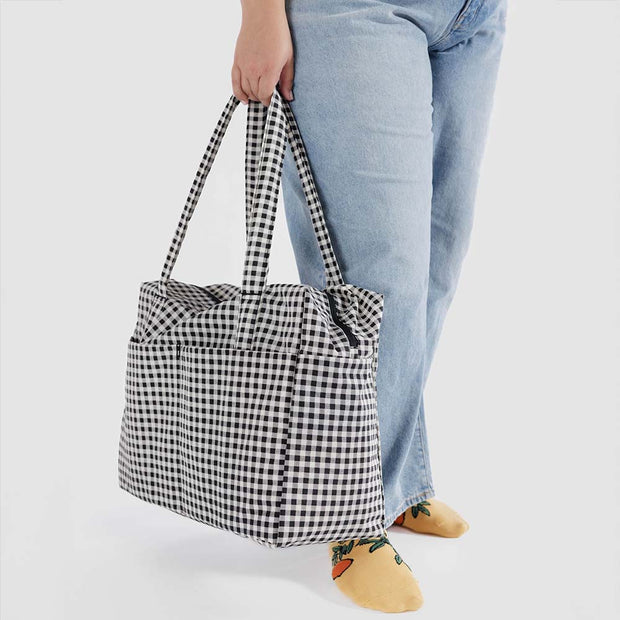 Person holding Baggu's Black & White Gingham Cloud Carry-on bag