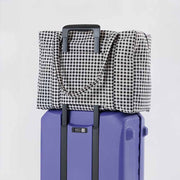 Baggu's Black & White Gingham Cloud Carry-on bag on suitcase