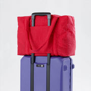 Candy apple red Baggu Cloud Carry-On on suitcase
