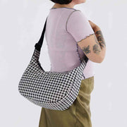 Close up of person holding A large Crescent Bag from Baggu in Black & White Gingham