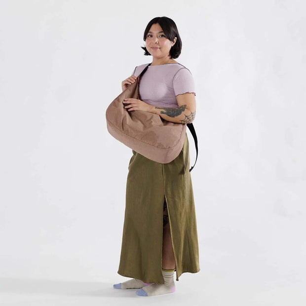 Woman holding A large Crescent Bag from Baggu in Cocoa