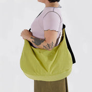 Close up of person holding A large Crescent Bag from Baggu in Lemongrass