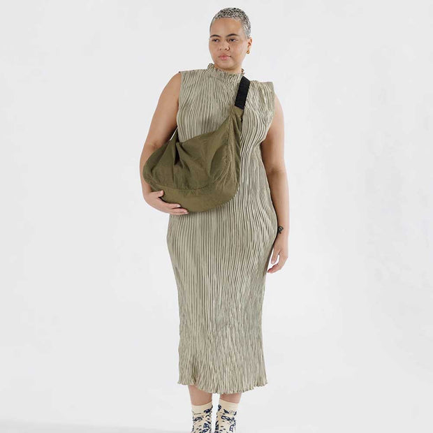 Woman holding A large Crescent Bag from Baggu in Seaweed