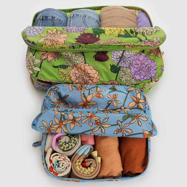 A set of Baggu large packing cubes in the Garden Flowers design including Orchid and Dahlia shown open and backed with clothing
