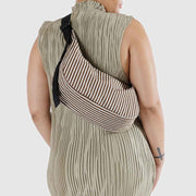A person wearing a Baggu medium Crescent Bag in Brown Stripe crossbody shown from the back