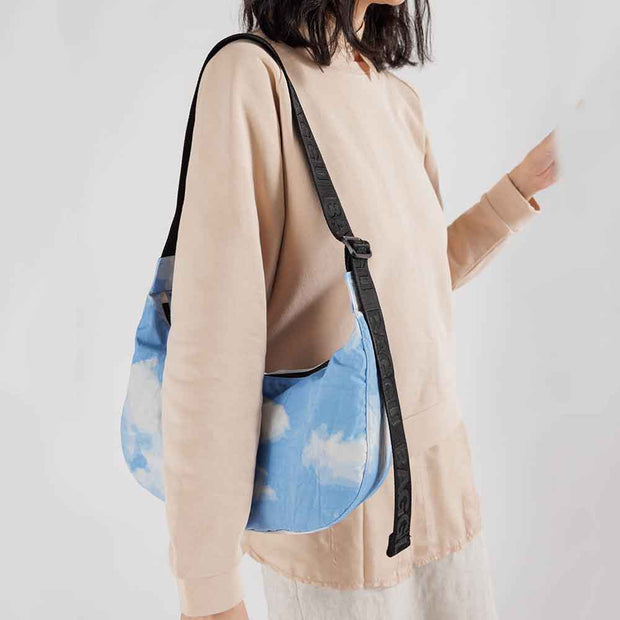 Person with A medium Crescent Bag from Baggu in Clouds over their shoulder