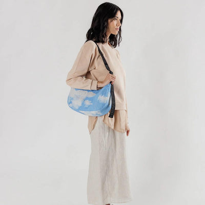 person with A medium Crescent Bag from Baggu in Clouds worn over their right shoulder