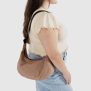 A person holding A medium Crescent Bag from Baggu in Cocoa