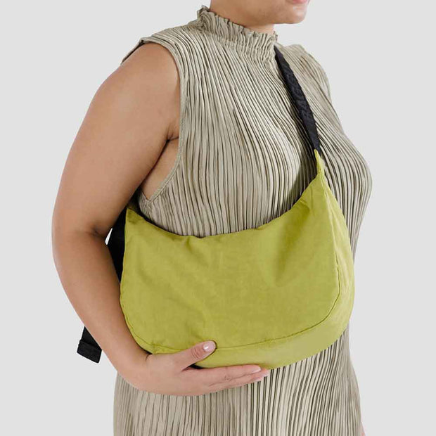 Close up of person holding Baggu medium Crescent Bag in Lemongrass