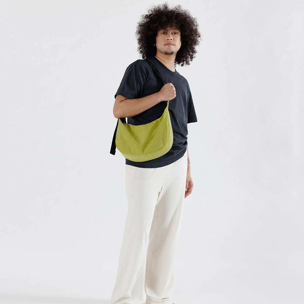 Man holding Baggu medium Crescent Bag in Lemongrass