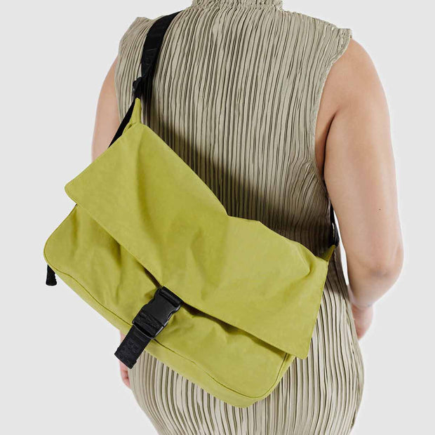 A person wearing a Baggu Recycled Nylon Messenger Bag in Lemongrass crossbody