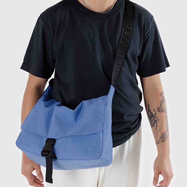 A Baggu Recycled Nylon Messenger Bag in Pansy Blue worn crossbody
