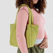 close up of a Baggu Lemongrass Mini Cloud Bag worn over a woman's shoulder