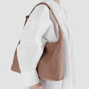 Person wearing Baggu nylon shoulder bag in Cocoa over shoulder