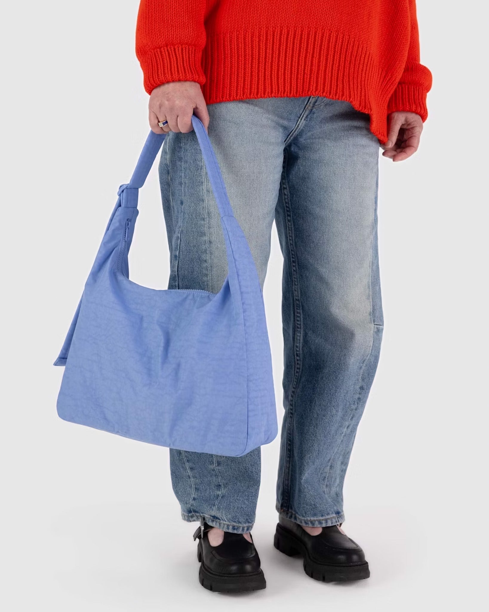A person holding a BAGGU recycled nylon shoulder bag in Cornflower