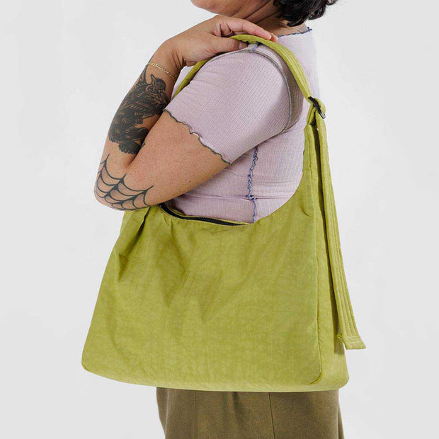 A woman holding a nylon Shoulder Bag from Baggu in Lemongrass close up