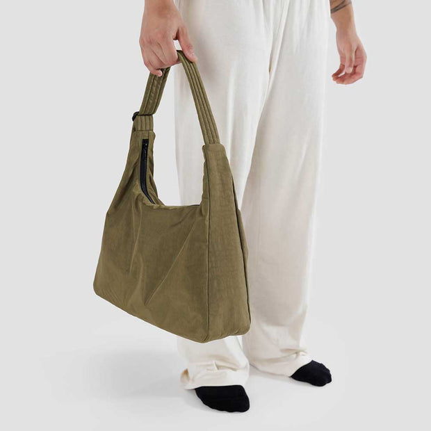 A close up of a person holding A Seaweed recycled nylon Shoulder Bag from Baggu