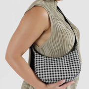 Person holding a small Baggu Crescent Bag in Black & White Gingham