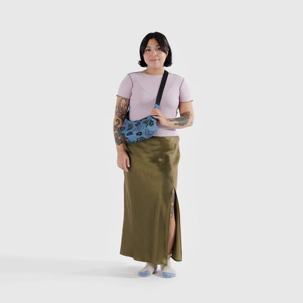 A person holding a small Crescent Bag from Baggu in Digital Denim Birds