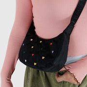 One small Crescent Bag from Baggu in Embroidered Hearts worn crossbody