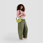 A woman with a small Baggu Crescent Bag in Lemongrass