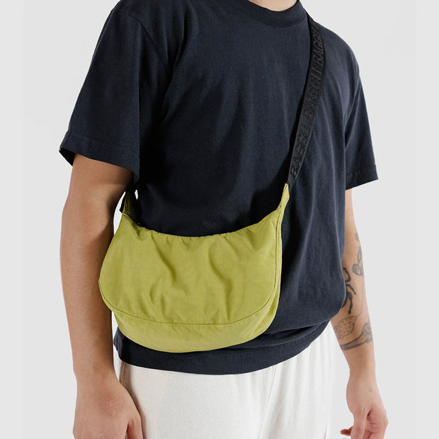 A man with A small Baggu Crescent Bag in Lemongrass 