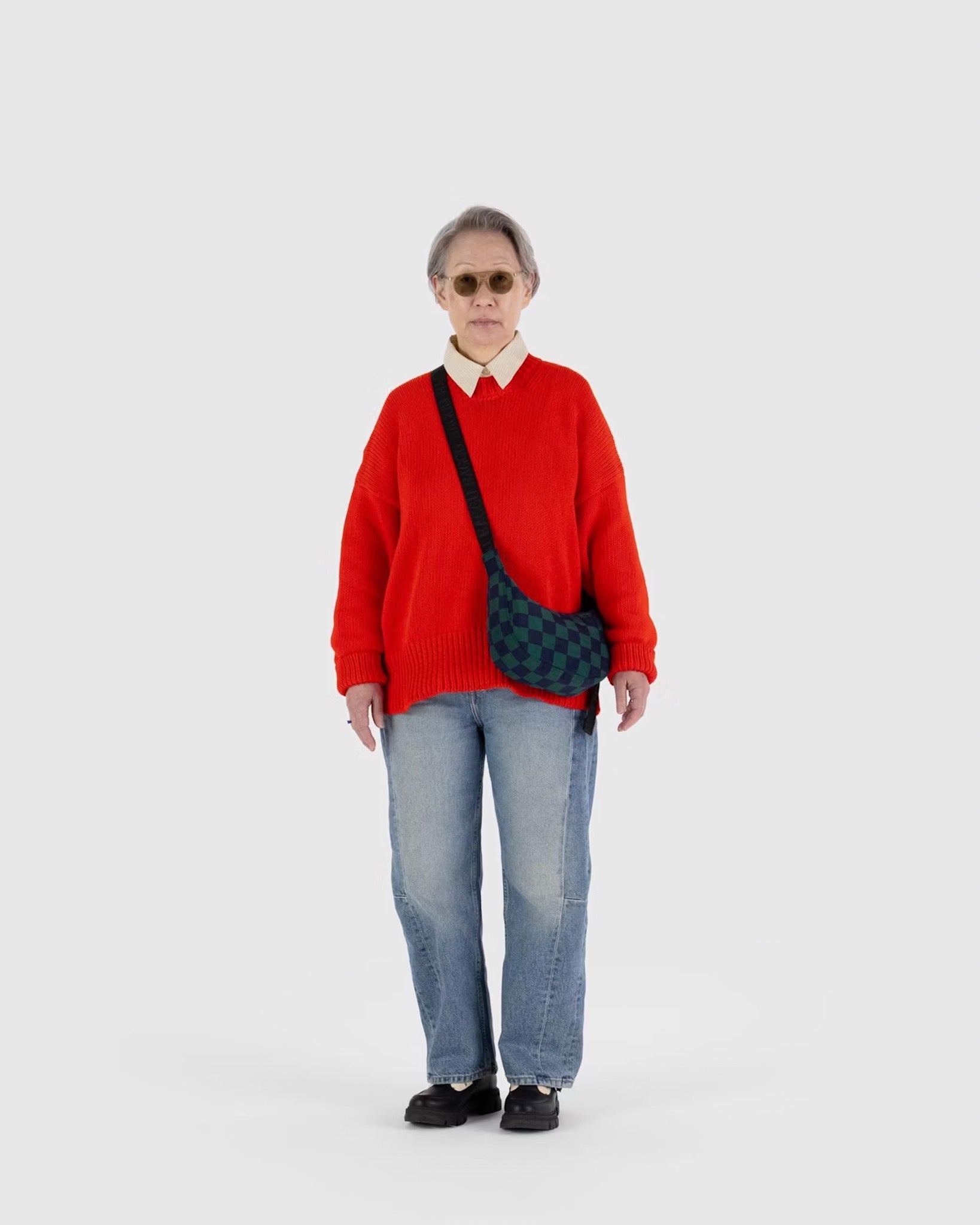 A person wearing a BAGGU small crescent bag in Navy Green Check 