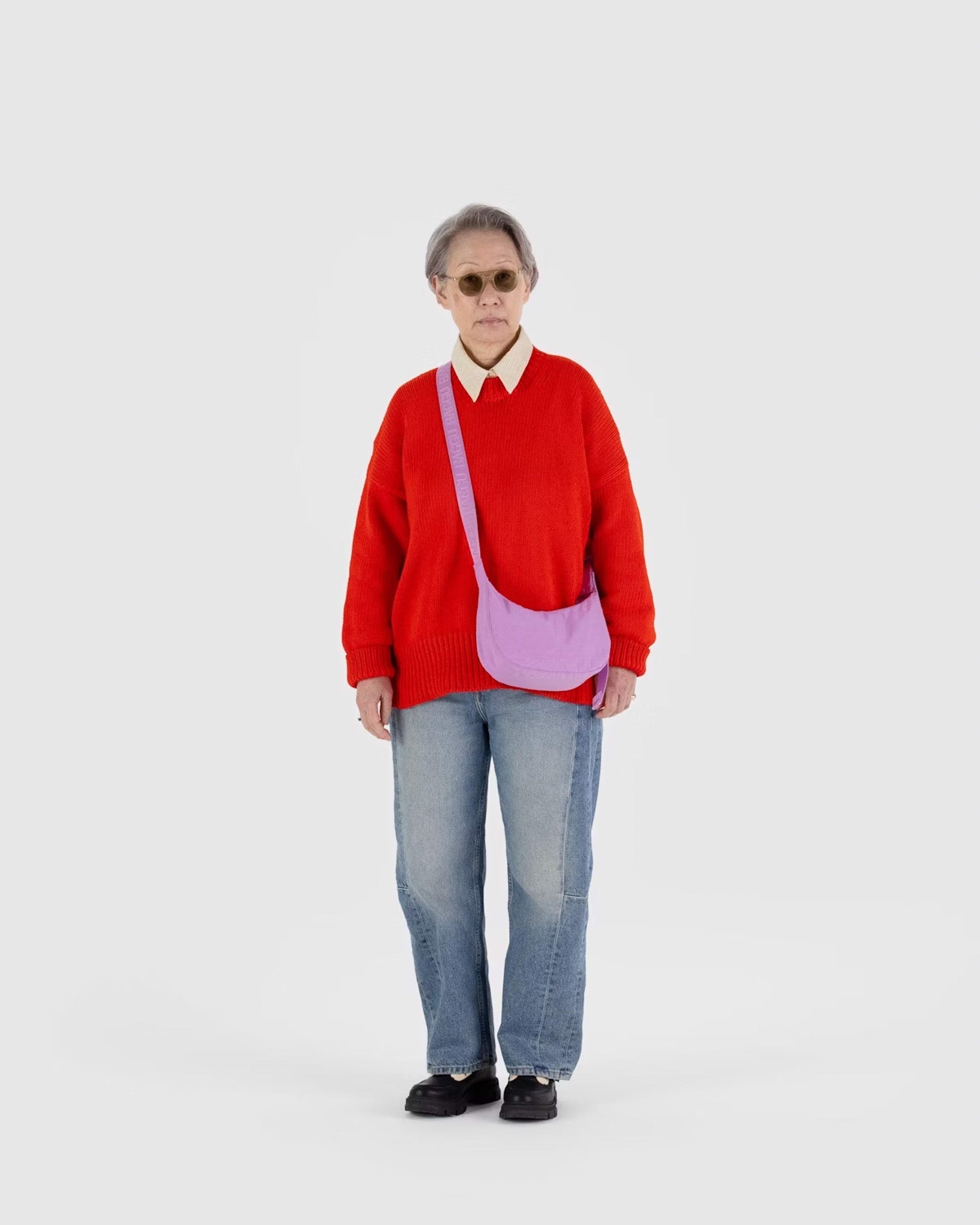 A person wearing a BAGGU small crescent bag in Peony 