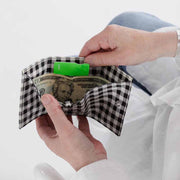 Open Baggu Black & White Gingham snap wallet being held open by a person