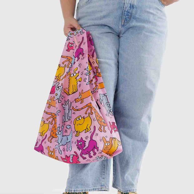 A person holding a Baggu Keith Haring Pets standard reusable bag